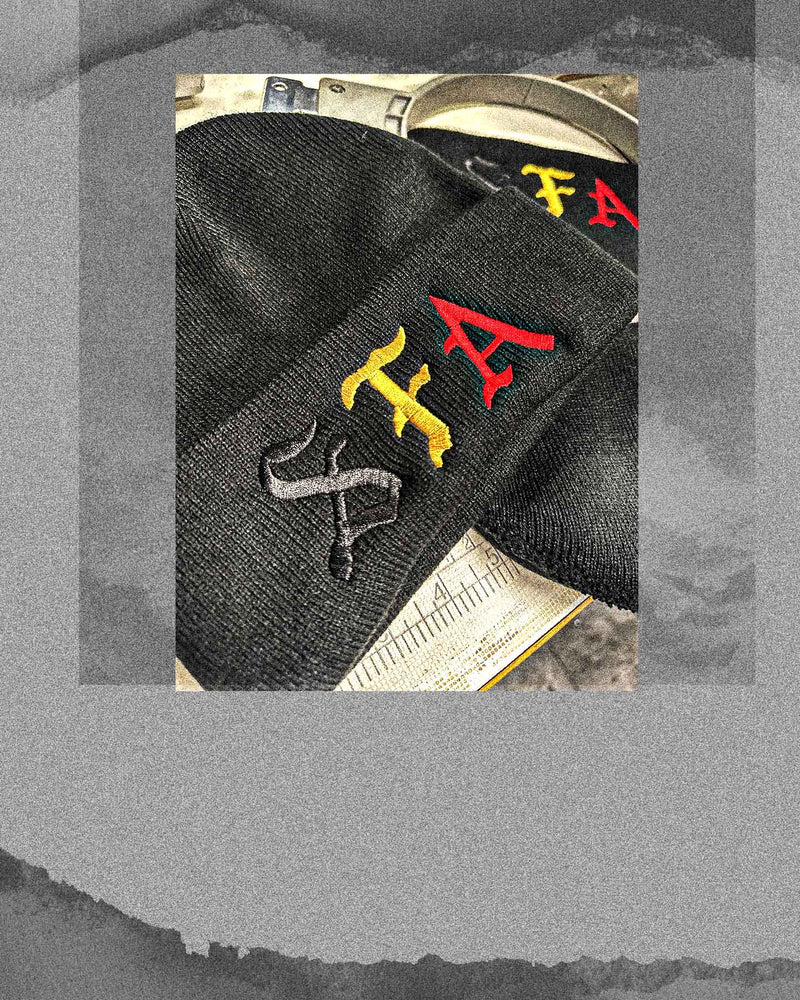 Close-up of black beanies with custom red and yellow embroidery